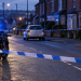 Illustrative image of a police cordon, motorcycle and silver car on a residential road
